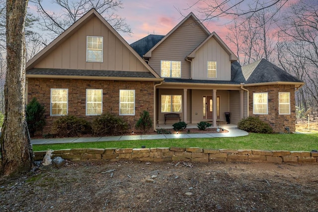 view of front of house with covered porch, stone siding, and board and batten siding