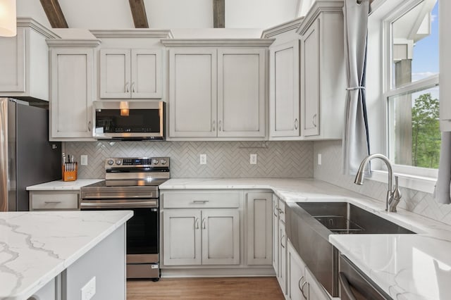 497 S Jakes Landing Way, Ellijay, GA 30540 - kitchen with appliances with stainless steel finishes, decorative backsplash, a sink, light stone countertops, and light wood-style flooring