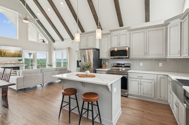 497 S Jakes Landing Way, Ellijay, GA 30540 - kitchen featuring appliances with stainless steel finishes, high vaulted ceiling, open floor plan, a kitchen breakfast bar, and tasteful backsplash
