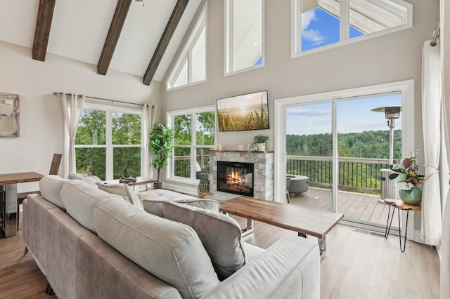 497 S Jakes Landing Way, Ellijay, GA 30540 - living area featuring high vaulted ceiling, wood finished floors, beam ceiling, and a stone fireplace