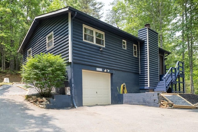 1214 Marrestop Rd, Murphy, NC 28906 - view of side of property with a chimney, an attached garage, faux log siding, and asphalt driveway