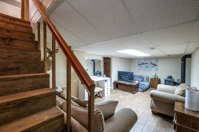 1214 Marrestop Rd, Murphy, NC 28906 - living area featuring a wood stove, stairs, wood finished floors, and a paneled ceiling