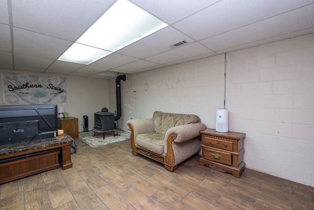 1214 Marrestop Rd, Murphy, NC 28906 - sitting room with a wood stove, wood finished floors, concrete block wall, and a drop ceiling
