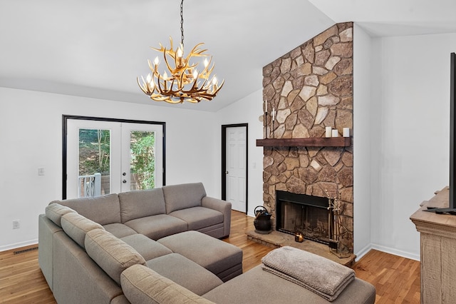 2790 Tamarack Dr, Jasper, GA 30143 - living area with a chandelier, vaulted ceiling, light wood finished floors, a fireplace, and french doors