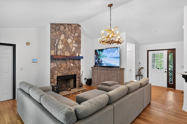 2790 Tamarack Dr, Jasper, GA 30143 - living area featuring a chandelier, vaulted ceiling, light wood-style flooring, and a stone fireplace