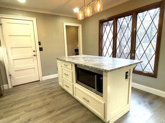 kitchen featuring white cabinets, plenty of natural light, a kitchen island, and pendant lighting