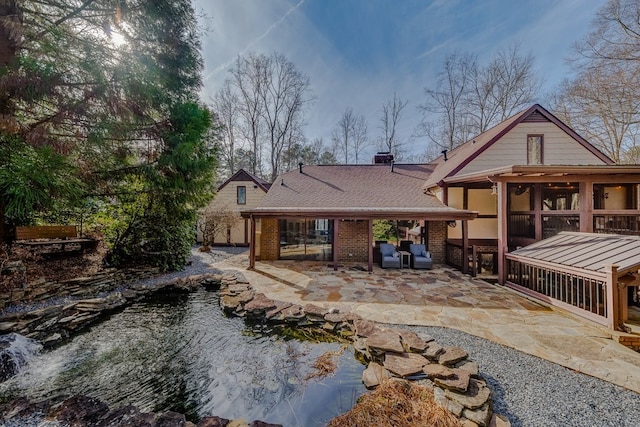 rear view of property featuring a patio and a sunroom