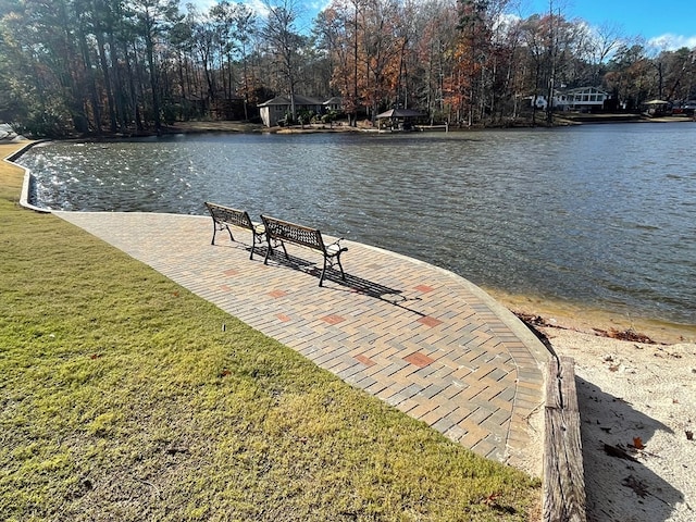 dock area with a lawn and a water view