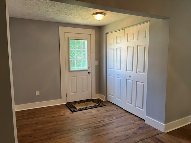 entryway featuring dark hardwood / wood-style flooring and a textured ceiling