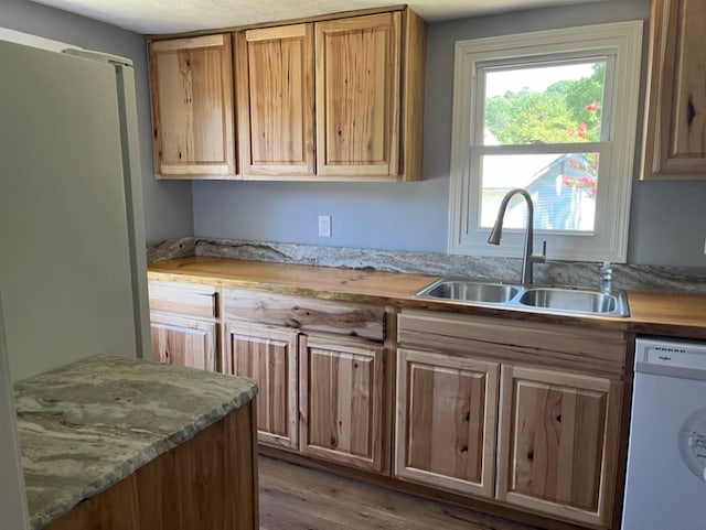 kitchen featuring dark wood-type flooring, sink, light stone counters, and dishwasher