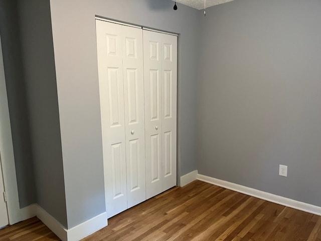 unfurnished bedroom with hardwood / wood-style flooring and a closet