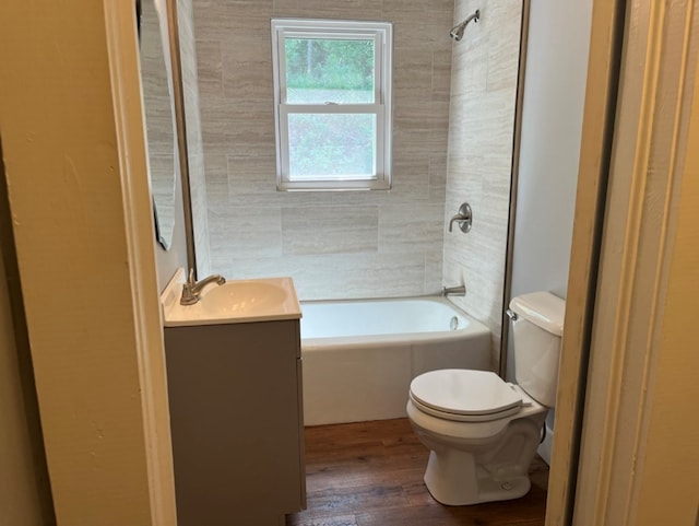 full bathroom featuring toilet, tiled shower / bath combo, vanity, and wood-type flooring