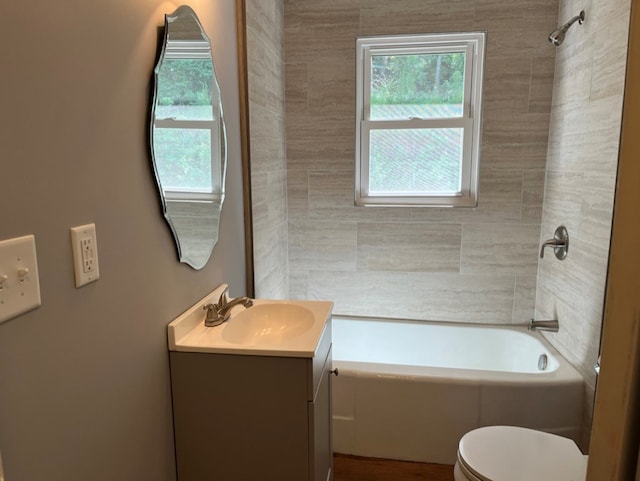 full bathroom with toilet, tiled shower / bath combo, and vanity