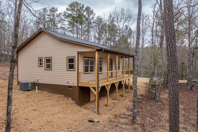 rear view of property featuring cooling unit and crawl space