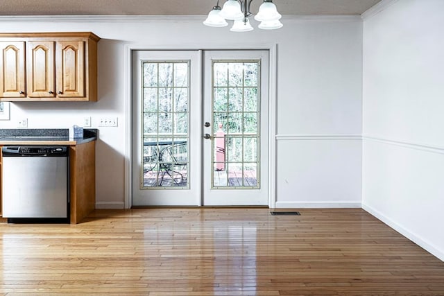 doorway featuring an inviting chandelier, crown molding, light hardwood / wood-style flooring, and french doors