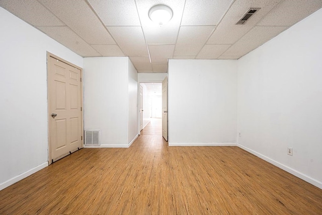 unfurnished room featuring a drop ceiling and light wood-type flooring