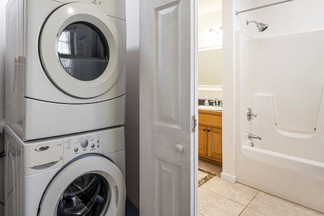 washroom with stacked washing maching and dryer, sink, and light tile patterned floors