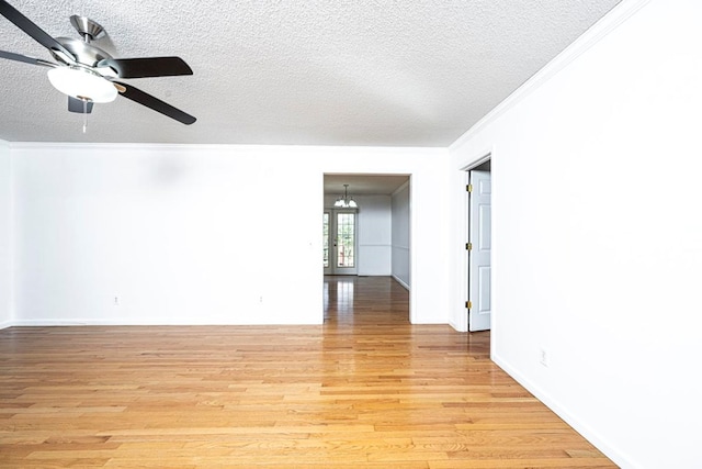 unfurnished room featuring crown molding, ceiling fan with notable chandelier, light hardwood / wood-style floors, and a textured ceiling