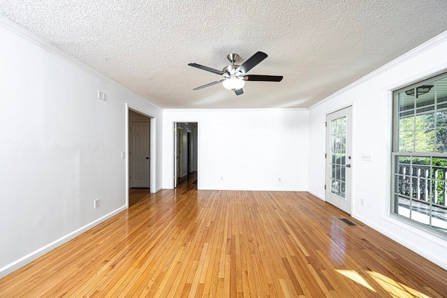 empty room with ornamental molding, light hardwood / wood-style floors, and a textured ceiling