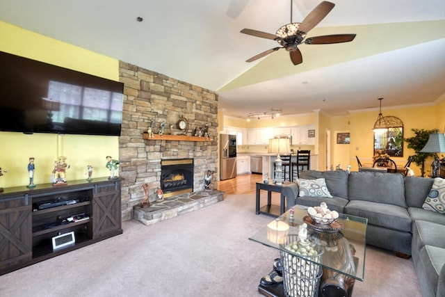 carpeted living room featuring crown molding, a stone fireplace, vaulted ceiling, and ceiling fan