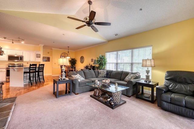 living room with light hardwood / wood-style floors, vaulted ceiling, a textured ceiling, crown molding, and ceiling fan