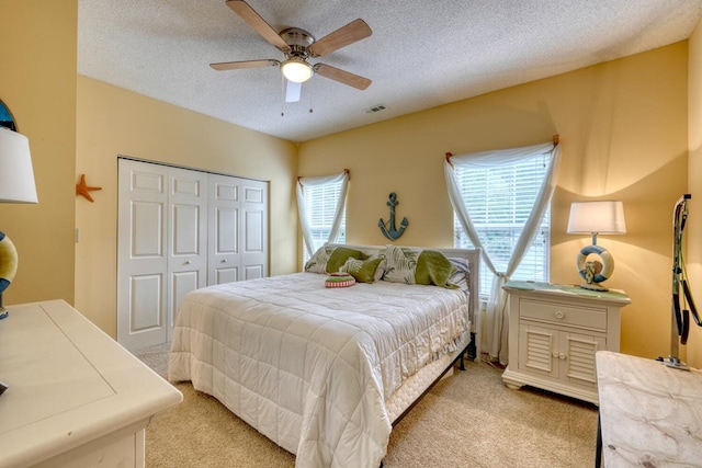 bedroom featuring ceiling fan, light colored carpet, and multiple windows