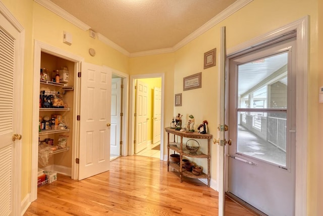 entryway featuring light hardwood / wood-style flooring, a textured ceiling, and crown molding