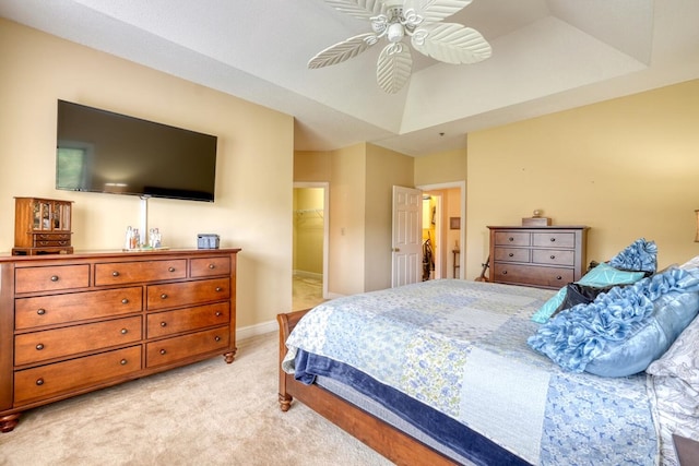 bedroom featuring a closet, ceiling fan, light colored carpet, and a walk in closet