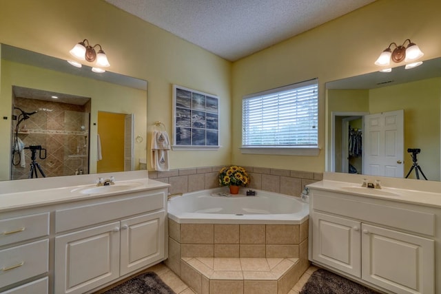 bathroom featuring vanity, shower with separate bathtub, a textured ceiling, and tile patterned floors