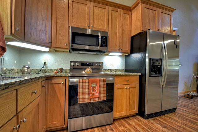 36 Rustic Barn Trl, Morganton, GA 30560 - kitchen with appliances with stainless steel finishes, light wood finished floors, brown cabinetry, and a textured wall