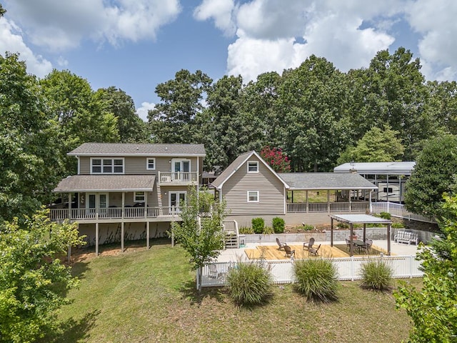 back of house featuring a yard, a balcony, a fenced backyard, and a patio area