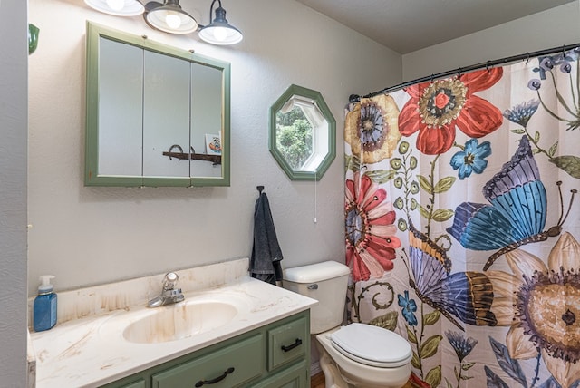 bathroom with vanity, curtained shower, and toilet