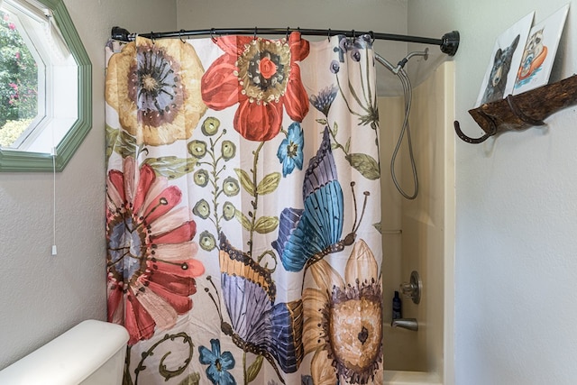 full bath with toilet and a textured wall