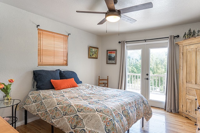 bedroom with access to exterior, french doors, light wood-type flooring, and a textured ceiling