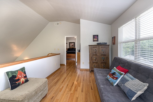 sitting room with visible vents, vaulted ceiling, and light wood finished floors