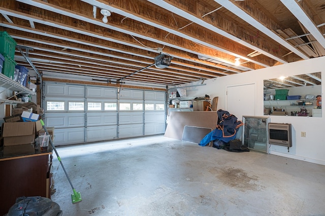 garage featuring heating unit and a garage door opener