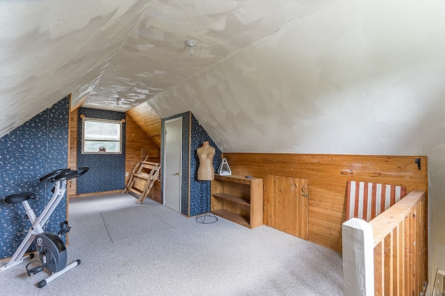 bonus room featuring carpet floors, lofted ceiling, and wood walls