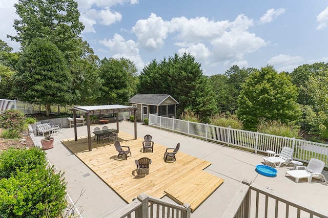 view of patio / terrace with fence, an outdoor fire pit, a deck, an outdoor structure, and a pergola