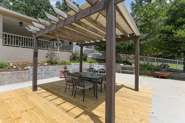 wooden deck with outdoor dining space, fence, and a pergola