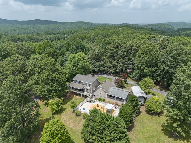 drone / aerial view with a wooded view