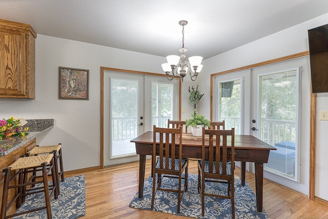 dining room featuring a notable chandelier, french doors, baseboards, and light wood-style floors