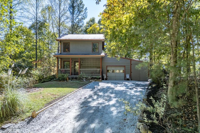 view of front of home with a front lawn, covered porch, and a garage