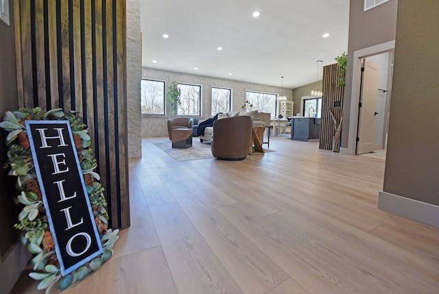 living area with light wood finished floors and recessed lighting