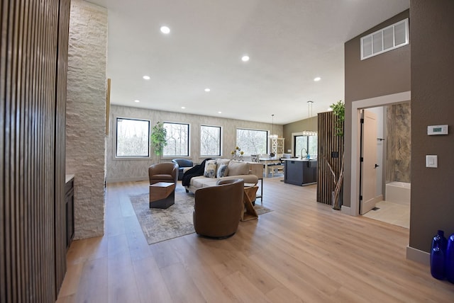 living room featuring recessed lighting, visible vents, and light wood finished floors