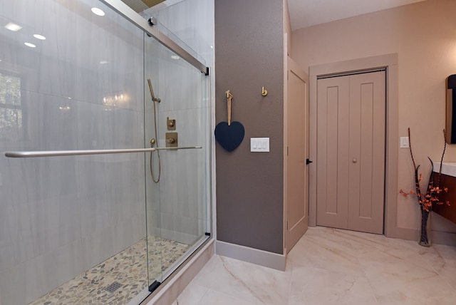 bathroom with a shower stall and baseboards