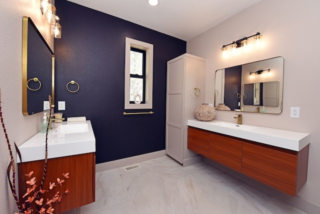 bathroom featuring visible vents, vanity, and baseboards