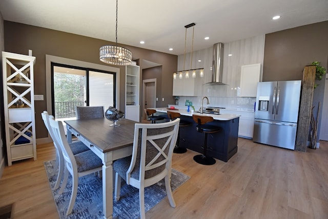 dining area featuring light wood-type flooring, an inviting chandelier, and recessed lighting