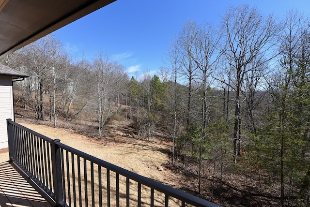 balcony featuring a wooded view