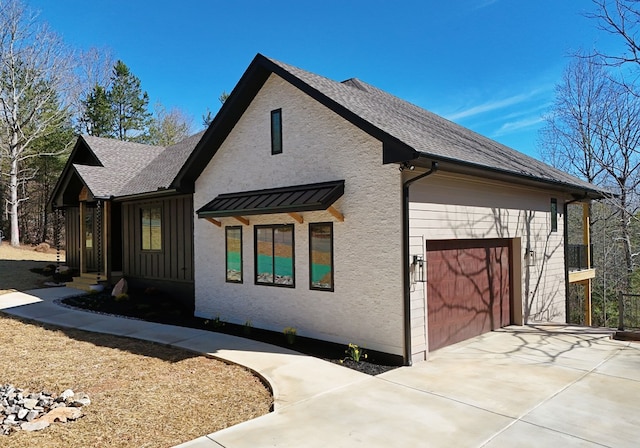 view of side of home featuring an attached garage, driveway, and roof with shingles