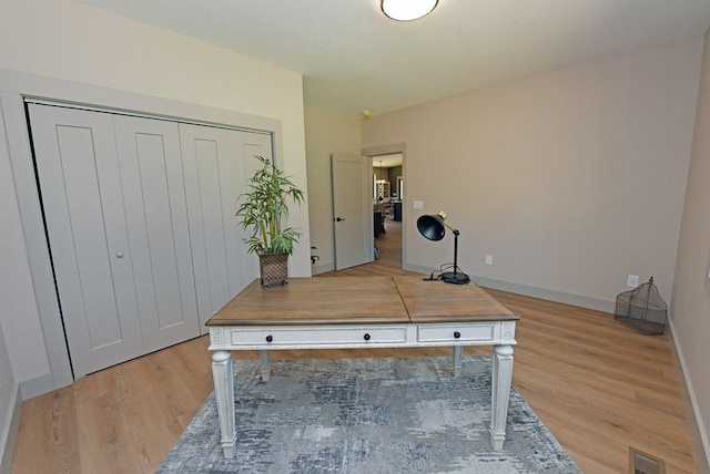 office with light wood-style floors, visible vents, and baseboards